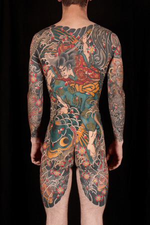 A stunning Japanese back piece tattoo featuring fish, sakura, sword, and a samurai done by the talented Stewart Robson.