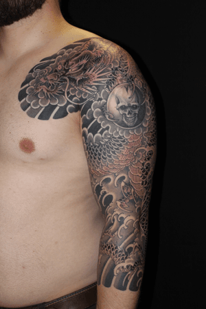 Stunning blackwork chest tattoo by Stewart Robson featuring a fierce dragon and skull design in traditional Japanese style.