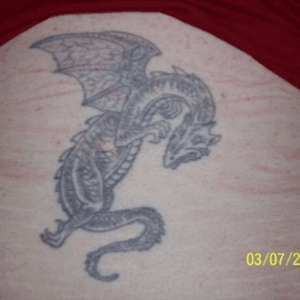 2nd tattoo. Laughed through the whole thing. It tickled so much. Sort of faded but it is 18 years old and was done by a newbie apprentice in the shop. Will eventually do a cover up with a better looking happy go lucky dragon.