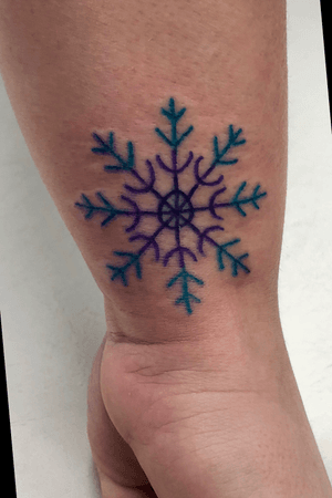 Colorful snowflake wrist tattoo.