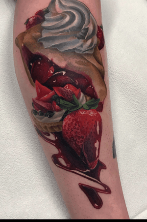 Color realistic tattoo of strawberry desserts on the leg.