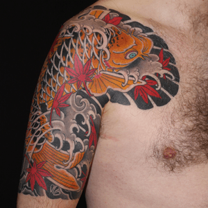 Experience the beauty of traditional Japanese art with this intricate tattoo featuring koi fish, flowers, and waves.