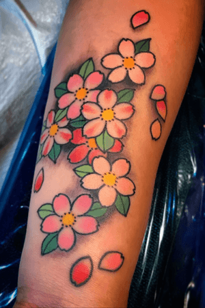 Illustrative traditional tattoo by Eddy Ospina featuring a beautiful cherry blossom motif on the forearm.