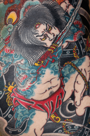 Stunning arm tattoo by Stewart Robson featuring a traditional Japanese sword and intricate depiction of a man.