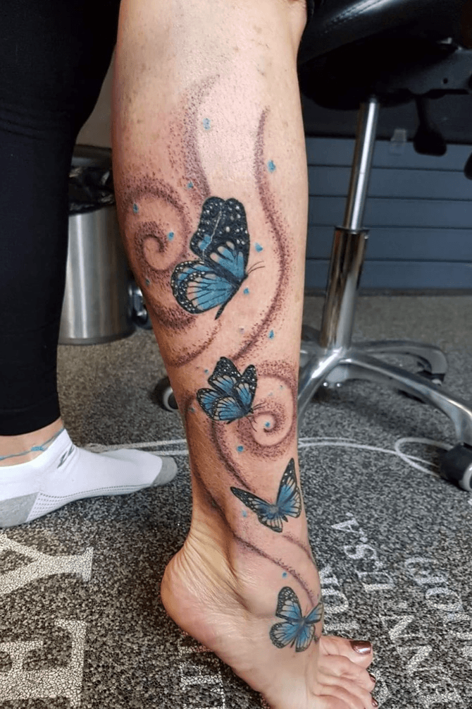 Calf tattoo of a butterfly by Ivy Saruzi