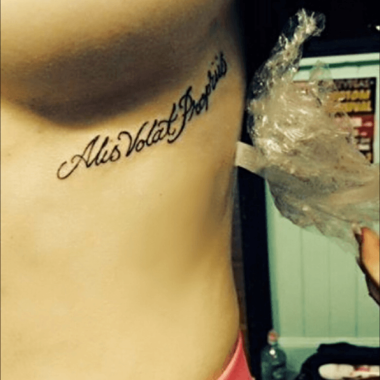 Alis volat propriis lettering tattoo on the side