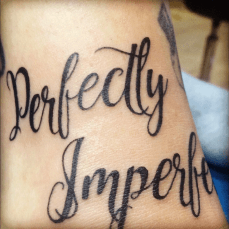 Be perfectly imperfect lettering tattoo on the hip