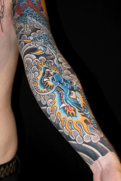 A fierce and detailed Japanese dragon tattoo design covering the entire sleeve, expertly executed by tattoo artist Stewart Robson.