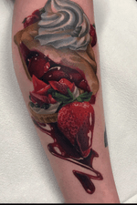 Color realistic tattoo of strawberry desserts in the leg.