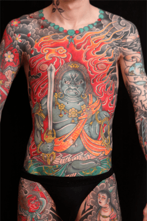 Incredible chest tattoo by Stewart Robson featuring a sword-wielding man with earrings in traditional Japanese style.
