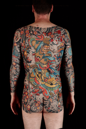Experience the beauty and strength of Japanese culture with this intricate body suit tattoo by Stewart Robson. Featuring a dynamic combination of flowers, swords, gods, samurais, and powerful waves.