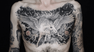 This blackwork tattoo by Stewart Robson features a stunning design of a celestial winged horse amidst a cosmic sky and universe motif.