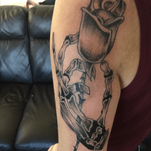 Skull hand holding rose