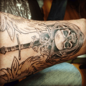 Inner forearm  skull on shield with sword and griffen heads on each side