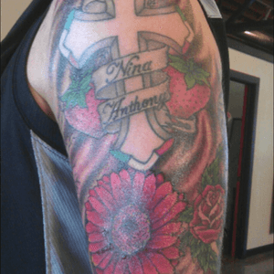 The cross represents my faith, edged out with colors of the Italian Flag. The Strawberries represent my last name in Italian, 2 for each of my kids. The Gerbera Daisy is my wifes favorite  flower.