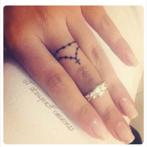 cross on ring finger tattoo