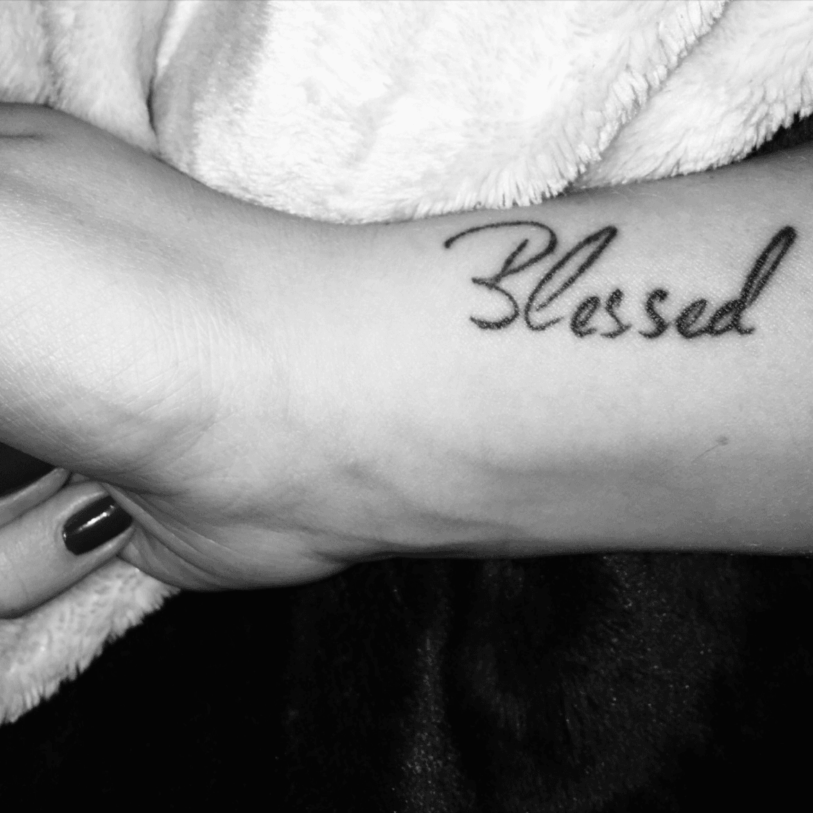 Blessed lettering tattoo on the tricep