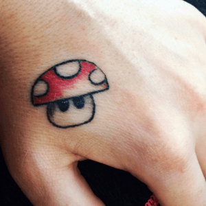 Red Mario mushroom hand tattoo by Angelina Sweeney at 18th st tattoo in eugene #mariotattoo #redmushroom #handtattoo #fridaythe13thspecial