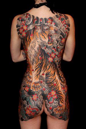 Stunning japanese style tattoo featuring a fierce tiger and delicate cherry blossom by renowned artist Stewart Robson.