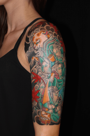 Elegant Japanese style upper arm tattoo of a mystical kitsune fox by renowned artist Stewart Robson.