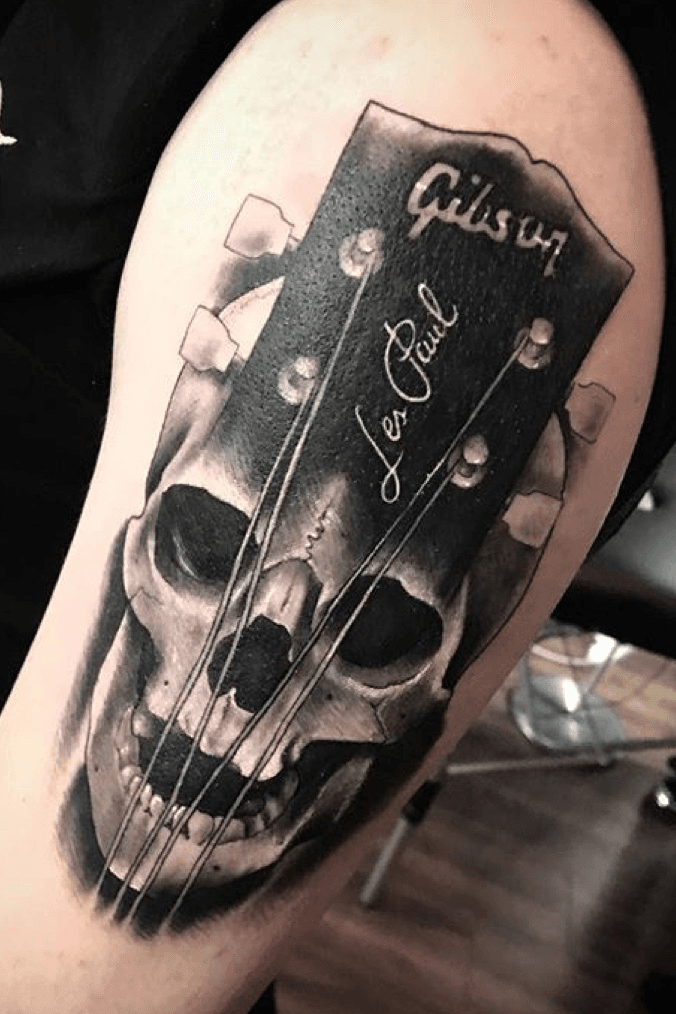 Neotraditional skull guitar tattoo on the inner