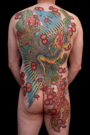 Stunning back piece tattoo by Stewart Robson featuring traditional Japanese motifs of sakura, a phoenix, and cherry blossoms.