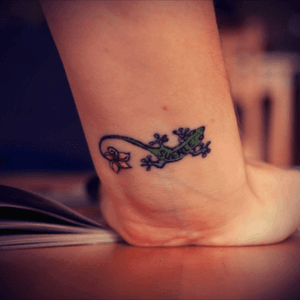 this is a memorial tattoo for my late mother-in-law: she lived on the Canary Islands where you have lots of lizards which are supposed to bring you good luck, hence the word "suerte" written in the body of the lizard, also you find the frangipani flowers (on the tip of the lizard's tail) on the Canaries