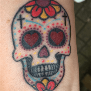 Colourful sugar skull tattoo, just over 2" long with heart eyes in the inside of my wrist