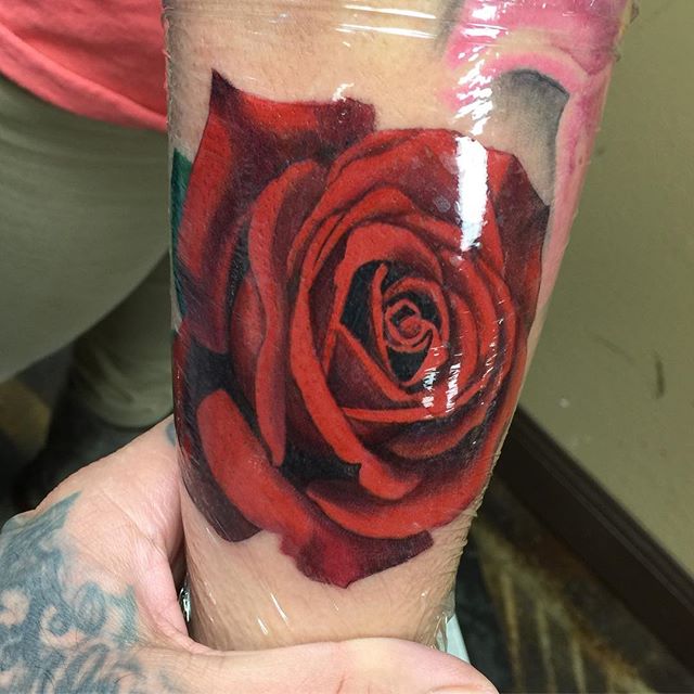 Illustrative red rose tattoo on the right side of the