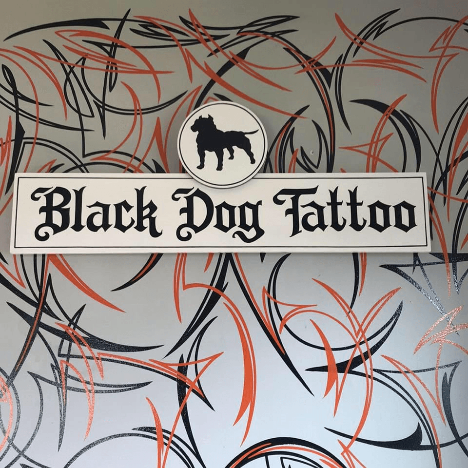 Black and grey dog tattoo on the right inner forearm