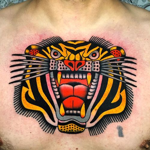 Chest tattoo by Geno Tattoo #GenoTattoo #chesttattoo #sternumtattoo #chestpiecetattoo #traditional #color #tiger #cat #junglecat #animal