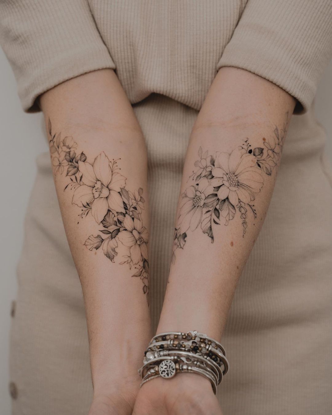 Fine line flower tattoo on the inner forearm